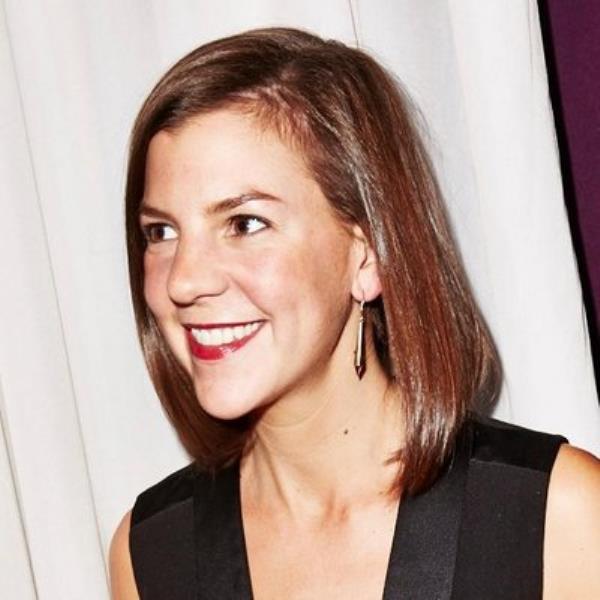 Charlotte Cowles, writer and columnist for New York Magazine's The Cut and the New York Times, smiling in front of a curtain.