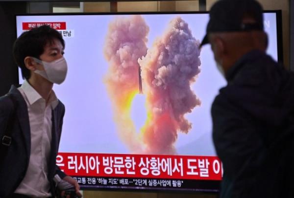 A man walks past a television screen showing a news broadcast with file footage of a North Korean missile test, at a railway station in Seoul on September 13, 2023. North Korea has fired two short-range ballistic missiles, the South Korean military said on September 13, with leader Kim Jong Un in Russia ahead of a summit with President Vladimir Putin. (Photo by Jung Yeon-je / AFP) (Photo by JUNG YEON-JE/AFP via Getty Images)