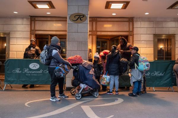 Families outside Roosevelt Hotel, Manhattan, reapplying for housing before city shelter deadline.