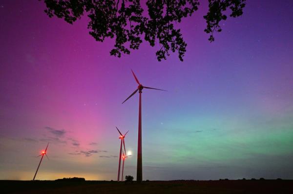 Light green and violet-reddish auroras, known as the northern lights, glowing in the night sky over the Oder-Spree district of East Brandenburg.