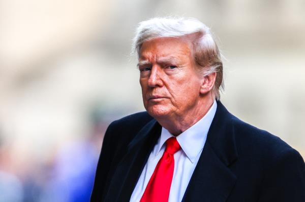 Former US President Do<em></em>nald Trump arrives at 40 Wall Street after his court hearing to determine the date of his trial for allegedly covering up hush mo<em></em>ney payments l<em></em>inked to extramarital affairs in New York City on March 25, 2024. 