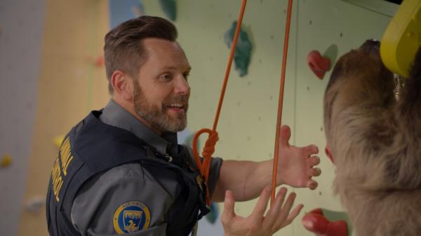 Joel McHale looking at a sloth. 