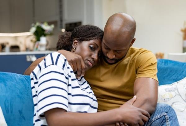 Man comforting his wife at home