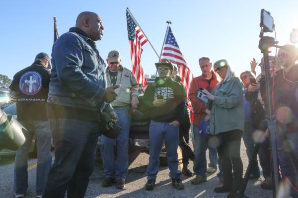 People standing outside with American flags. 