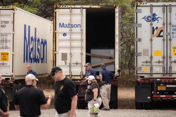 A fleet of trucks, being used to store bodies found in the rubble of the houses are parked after arriving to the Maui area.