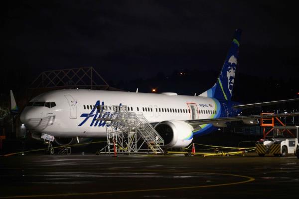 A plastic sheet covers an area of the fuselage of the Alaska Airlines N704AL Boeing 737 MAX 9 aircraft outside a hangar at Portland Internatio<em></em>nal Airport on January 8, 2024 in Portland, Oregon