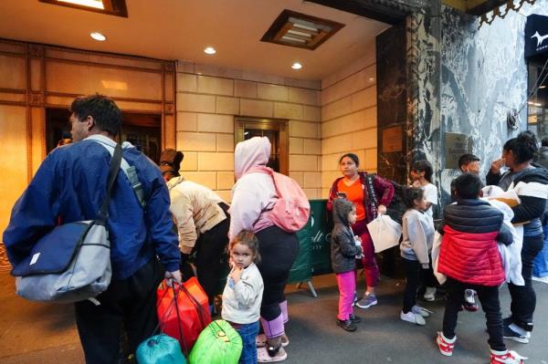 Migrants outside the Roosevelt Hotel shelter