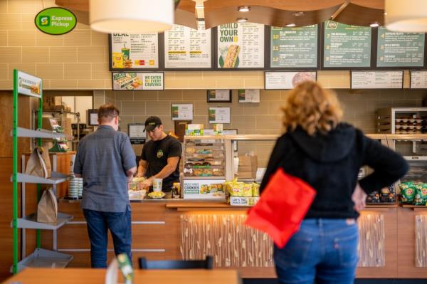 Customers wait in line at a Subway restaurant on January 12, 2023 in Austin, Texas.