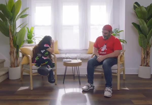 Natalia Grace sitting in a chair facing a man in a red shirt. 