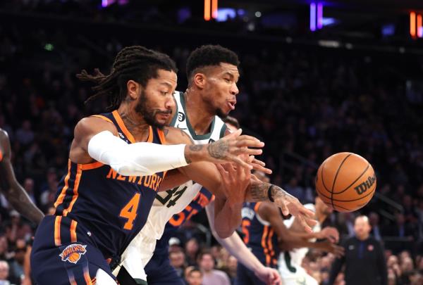 Derrick Rose and Giannis Antetokounmpo wrestle for the ball.