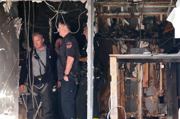 Firefighters investigate remains of the fire.