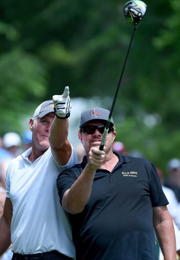 Toby Keith and Brett Favre pointing at a golf club during round two of the American Family Insurance Champio<em></em>nship in Madison, Wisconsin.