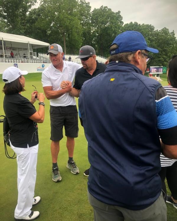 Brett Favre and Toby Keith standing together smiling on a golf course.