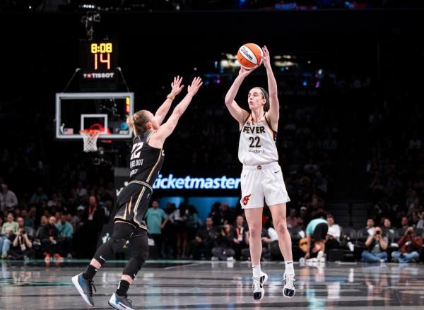 Caitlin Clark makes shot against Courtney Vandersloot #22 of the New York Liberty during their home opener at Barclays Center. 