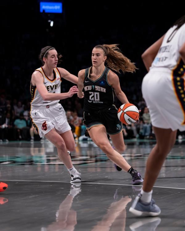 Sabrina Io<em></em>nescu #20 of the New York Liberty handles ball vs Caitlin Clark #22 of the Indiana Fever during their home opener at Barclays Center.