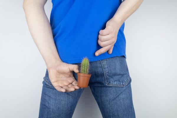 Photo of a man with a cactus in his rear end. 