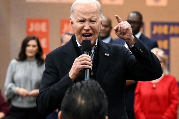 Joe Biden speaking into a microphone during his visit to a United Auto Workers phone bank in Michigan.