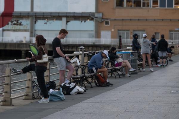 Group of tennis players and instructors lined up early morning at Hudson River Park courts, NY