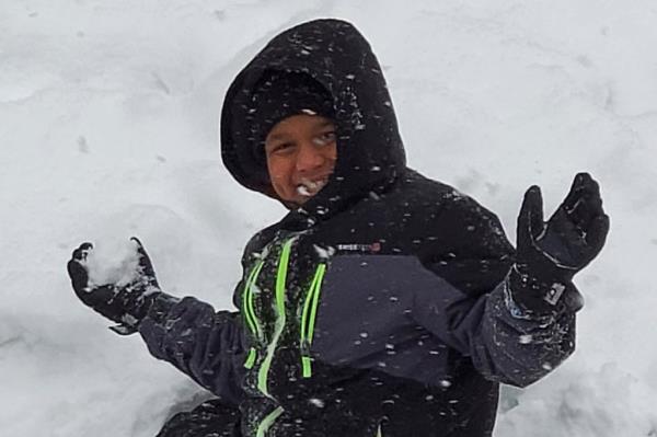 Ahmir Joliff grips a snowball in the snow.