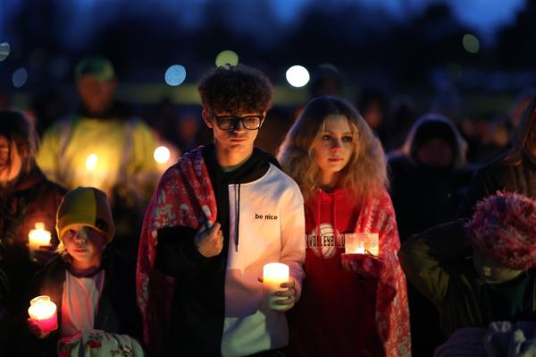 Students pay their respects at a candlelight vigil.