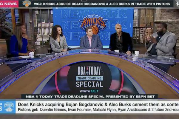 A group of people sitting at a table, including Richard Jefferson and Brian Windhorst.