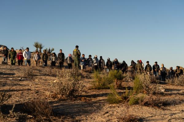 A Border Patrol agent with migrants who crossed the border in Jacumba Hotsprings, California on November 8, 2023.