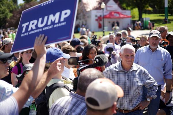 Republican U.S. Presidential candidate and former Vice President Mike Pence speaks to members of the press as a Trump supporter holds up a Trump campaign sign at the Iowa State Fair on August 11, 2023.