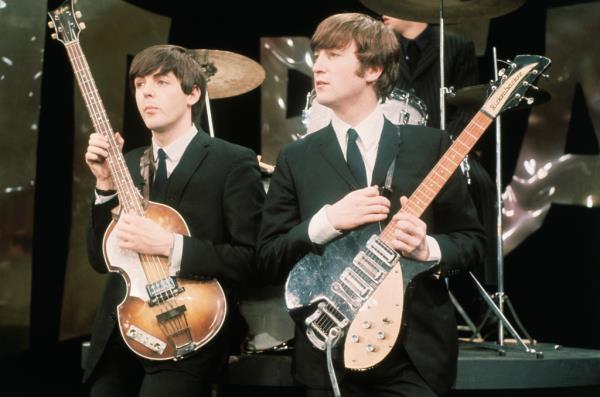 Paul McCartney and John Lennon hold their guitars while on the set of The Ed Sullivan Show at the CBS television studios in Manhattan