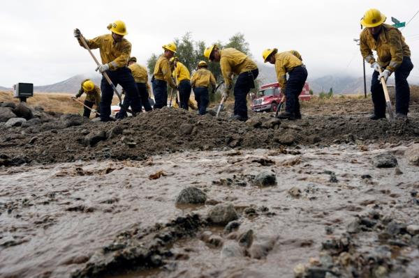 Members of Cal Fire Pilot Rock 6 crew, out of Crestline, Calif., clear mud off the side of the road in the aftermath of Tropical Storm Hilary, on Aug. 21, 2023, in Yucaipa, Calif. 