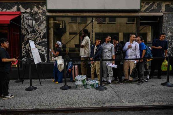 Recently arrived migrants wait outside a processing center in New York on July 28, 2023