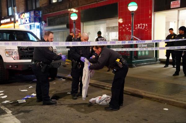 Cops securing bloody belo<em></em>ngings of East Harlem shooting victim