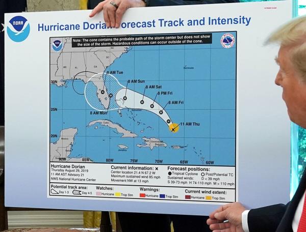 President Do<em></em>nald Trump (R) references a map held by acting Homeland Security Secretary Kevin McAleenan while talking to reporters following a briefing from officials a<em></em>bout Hurricane Dorian in the Oval Office at the White House September 04, 2019 in Washington, DC.