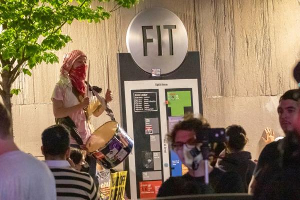 An anti-Israel protesters bangs on a drum outside FIT on W 27th St near 8th Ave in Manhattan on Tuesday.