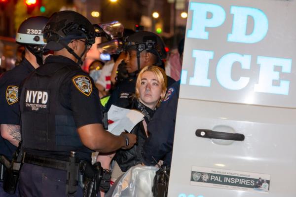 Protesters are placed into NYPD vehicles before being transported away from the encampment.