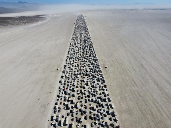 An overhead view of a massive traffic jam of cars, trucks and trailers carrying festival-goers leaving the 2023 Burning Man festival in the Nevada desert.