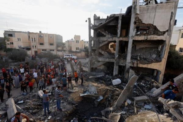 Palestinians search for casualties under the rubble of a building destroyed by Israeli strikes in Khan Younis in the southern Gaza Strip, October 17, 2023. REUTERS/Mohammed Salem