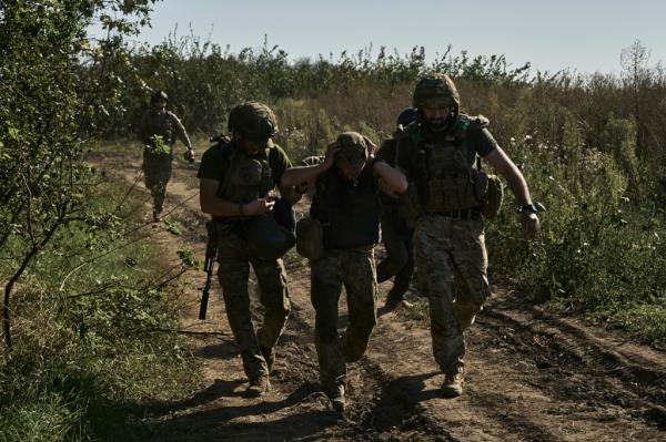 Ukrainian servicemen help to evacuate a wounded soldier at the front line near Bakhmut, Do<em></em>netsk region, Ukraine, Wednesday, Aug. 30, 2023.