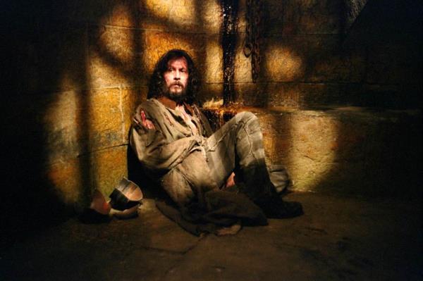 Gary Oldman sitting in a prison cell in 