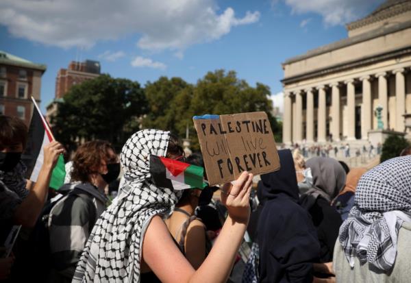 A pro-Palestinian demo<em></em>nstrator holds a sign that reads 