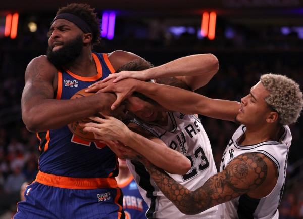 Mitchell Robinson #23 of the New York Knicks fights for the rebound against Zach Collins #23 and Jeremy Sochan #10 of the San Anto<em></em>nio Spurs