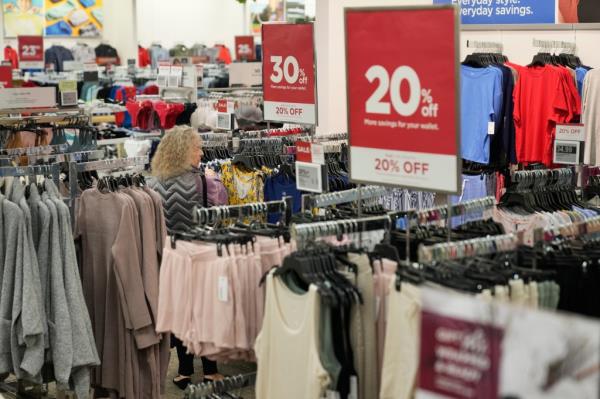 Shopper looks at clothes with sale sign in Kohl's store.