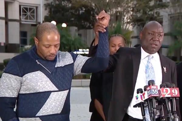 Yarnell Sampson's hand is raised in the air by family attorney Ben Crump following the verdict on Dec. 5, 2024.