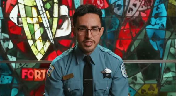 Slain Chicago Police Officer Luis Huesca in uniform and glasses sitting in front of a stained glass window