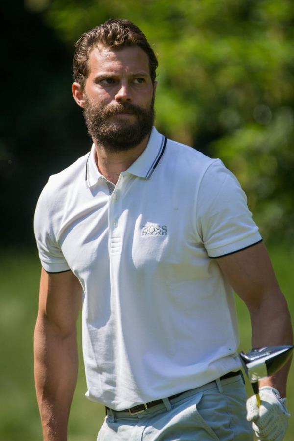 Jamie Dornan looking serious playing golf. 