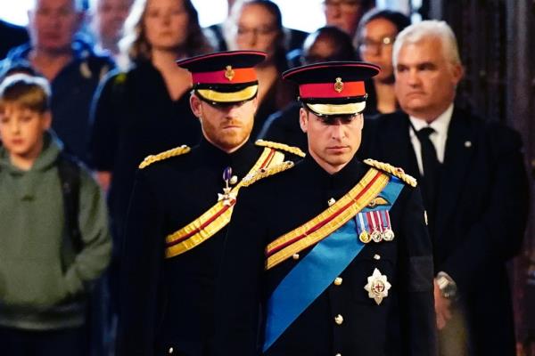 Prince William, Prince of Wales, and Prince Harry, Duke of Sussex, in military uniforms, standing vigil at Westminster Hall in ho<em></em>nor of their grandmother, Queen Elizabeth II.