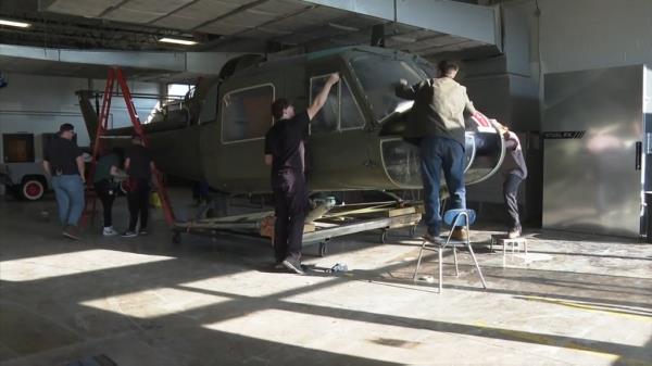 Students work on the UH-1 Huey, a famed piece of military machinery that's been featured in films like 