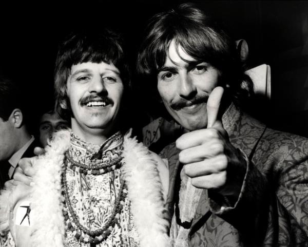 Ringo Starr and George Harrison, holding up a thumb