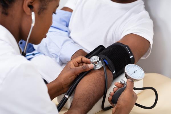 Doctor's hand closely measuring the blood pressure of a male patient