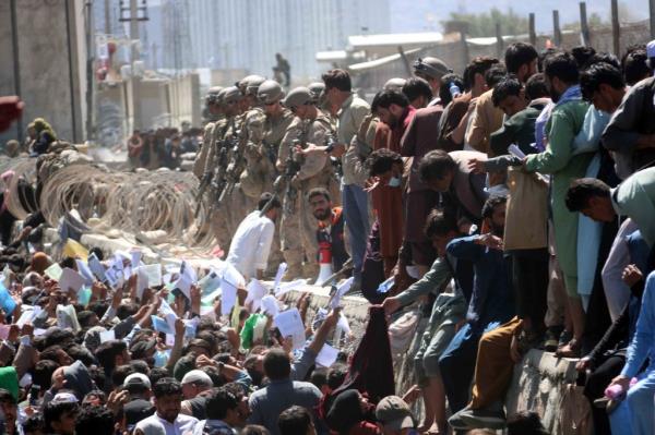 Afghans struggle to reach the foreign forces to show their credentials to flee the country outside the Hamid Karzai Internatio<em></em>nal Airport, in Kabul.