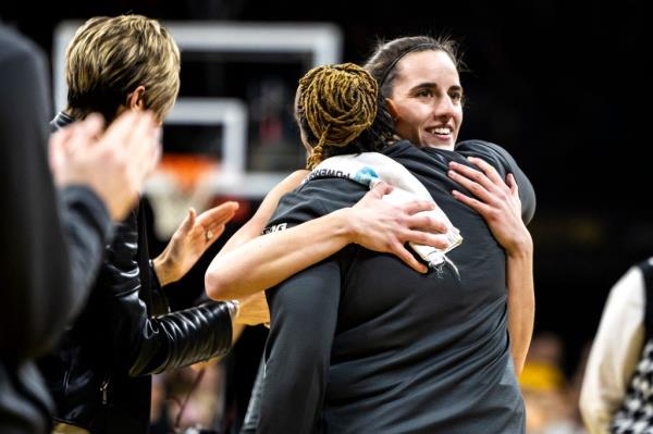 Iowa Hawkeyes guard Caitlin Clark (22) hugs assistant coach Raina Harmon during women's basketball game against Michigan at Carver-Hawkeye Arena.